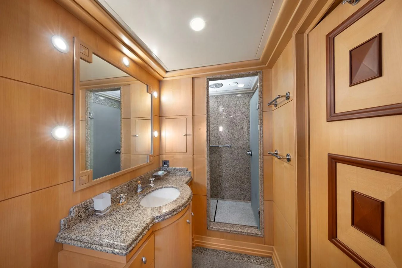 The yacht's bathroom features elegant wood paneling and a granite countertop, creating a luxurious and serene atmosphere. aboard HAPPY DOLPHIN II Yacht for Sale