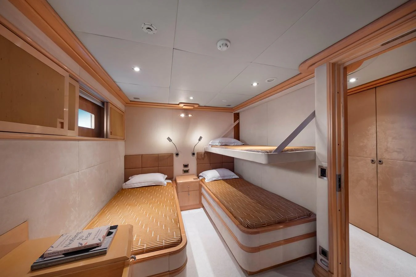The guest stateroom features twin beds and a bunk, offering a cozy and functional sleeping area. aboard HAPPY DOLPHIN II Yacht for Sale