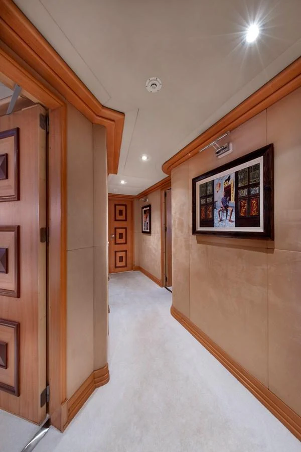 The hallway features elegant wood trim and tasteful artwork, creating a warm and inviting atmosphere. aboard HAPPY DOLPHIN II Yacht for Sale