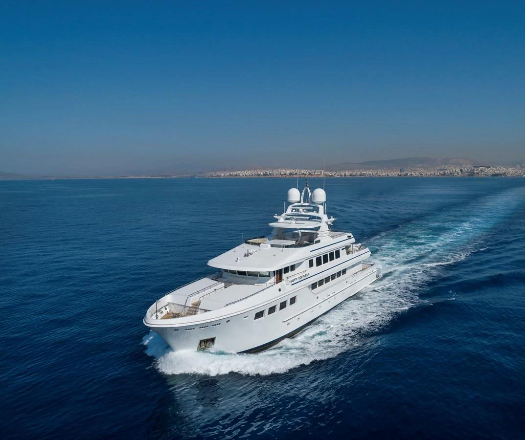 A luxurious yacht cruises through the open sea under a clear blue sky. aboard HAPPY DOLPHIN II Yacht for Sale