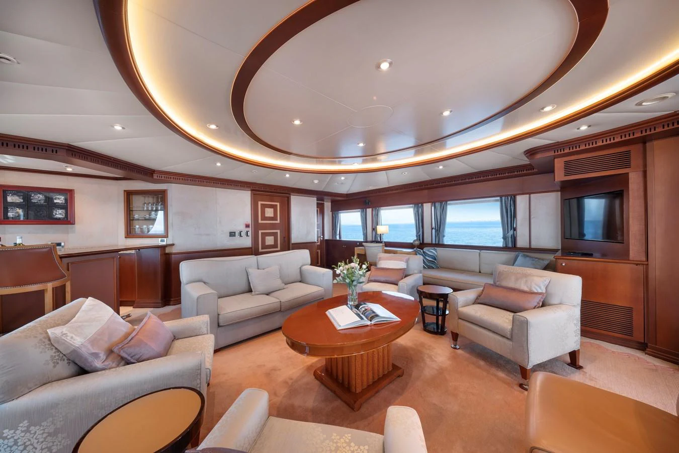 The salon offers a spacious and elegant seating area with panoramic views. aboard HAPPY DOLPHIN II Yacht for Sale