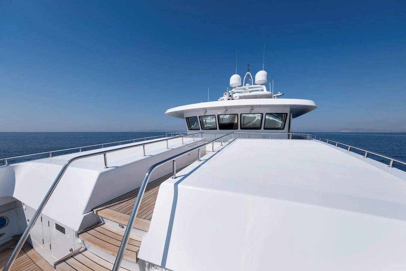 The yacht's sleek exterior showcases its modern design and expansive deck space under a clear blue sky. aboard HAPPY DOLPHIN II Yacht for Sale
