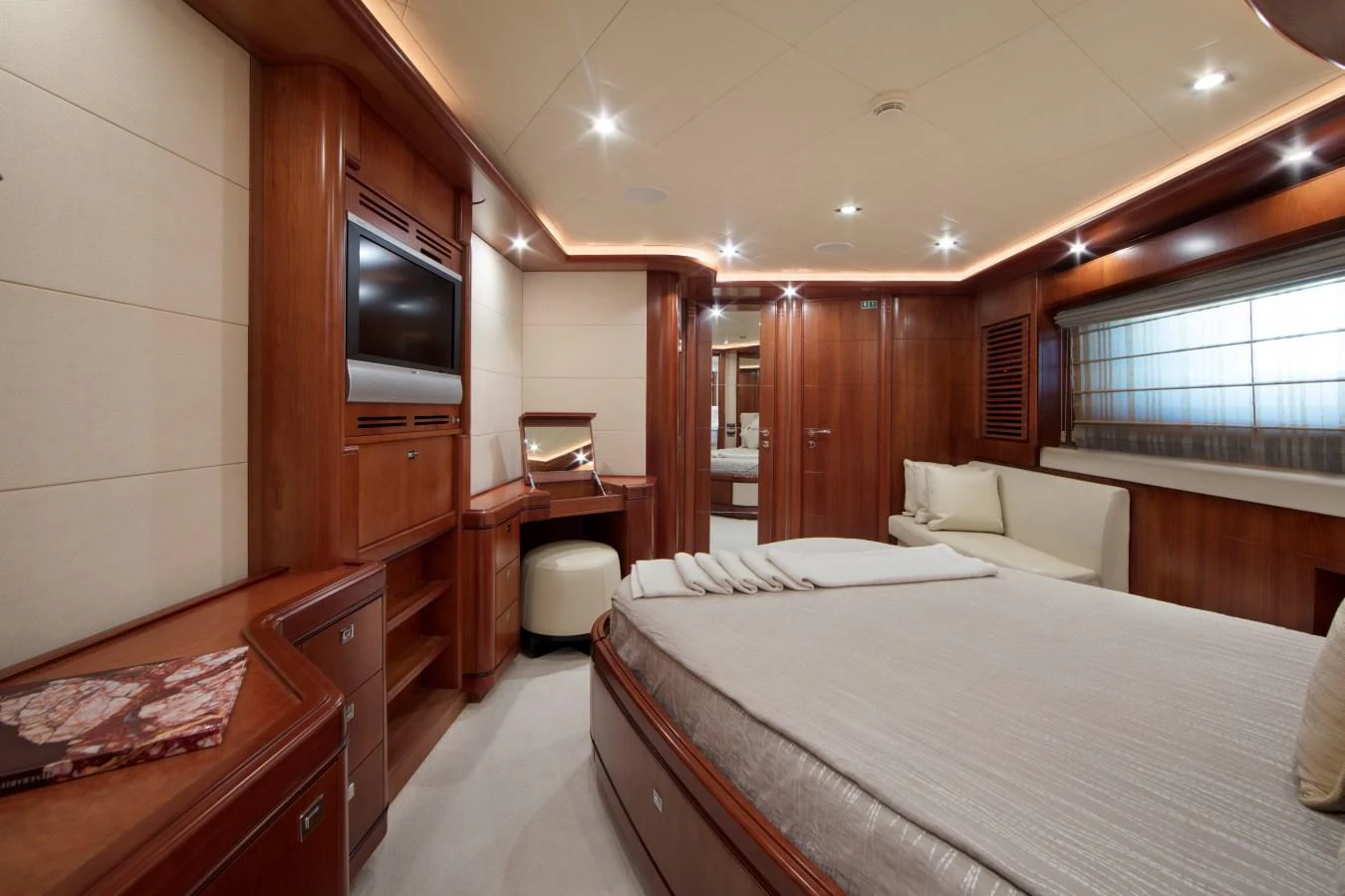The master stateroom features luxurious wood finishes, a comfortable bed, and ample natural light. aboard SIMA Yacht for Sale