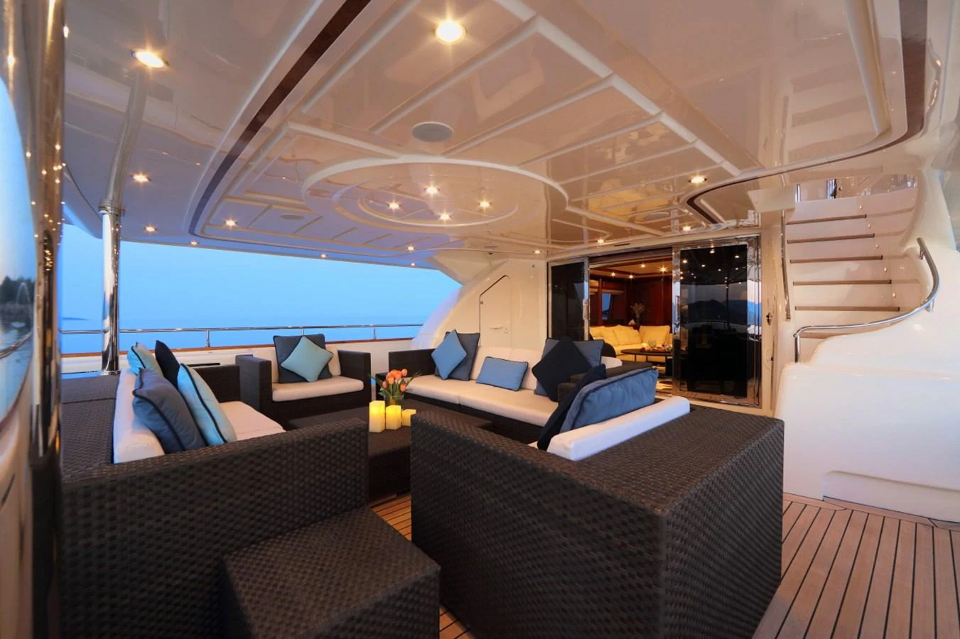 The aft deck features elegant wicker seating with plush cushions, perfect for relaxing and entertaining. aboard SIMA Yacht for Sale