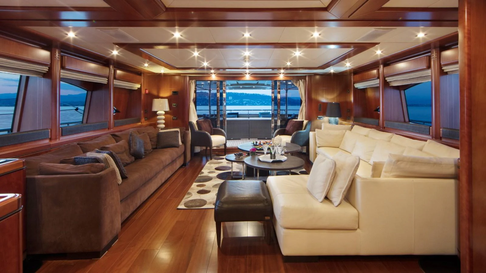 The yacht's salon features luxurious seating and a panoramic view of the sea. aboard SIMA Yacht for Sale