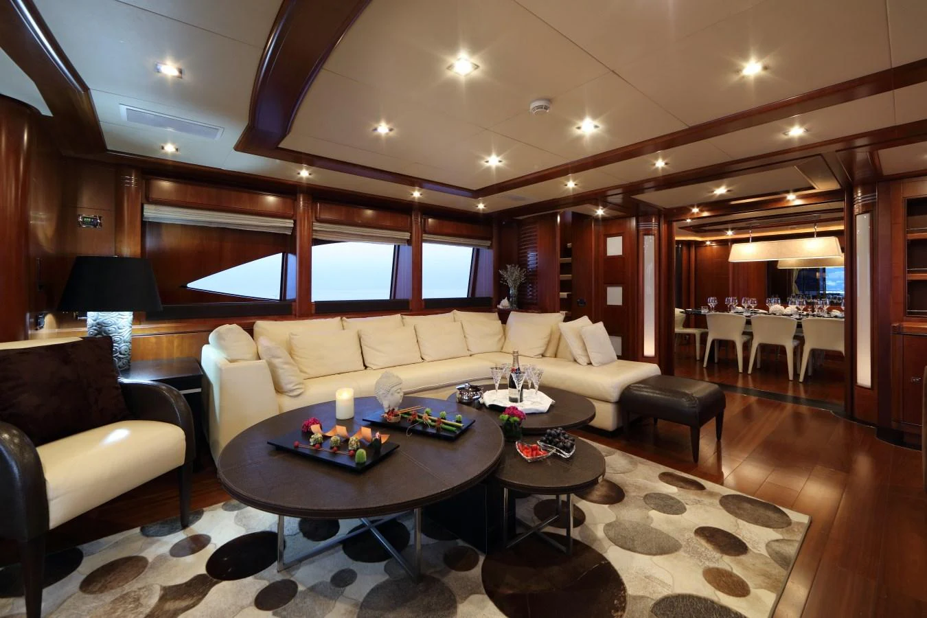 The salon features elegant wood paneling, plush seating, and a sophisticated dining area. aboard SIMA Yacht for Sale
