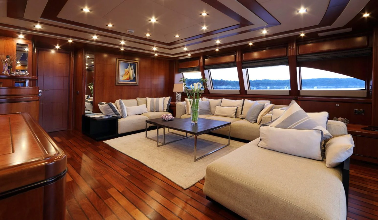 The salon features luxurious seating with panoramic windows offering stunning views. aboard SIMA Yacht for Sale