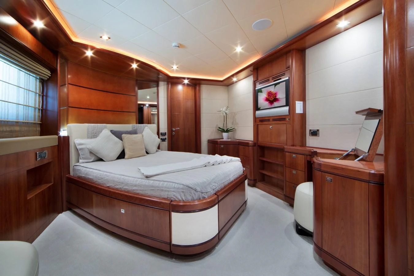 The master stateroom features luxurious wood paneling, a plush bed, and elegant lighting. aboard SIMA Yacht for Sale