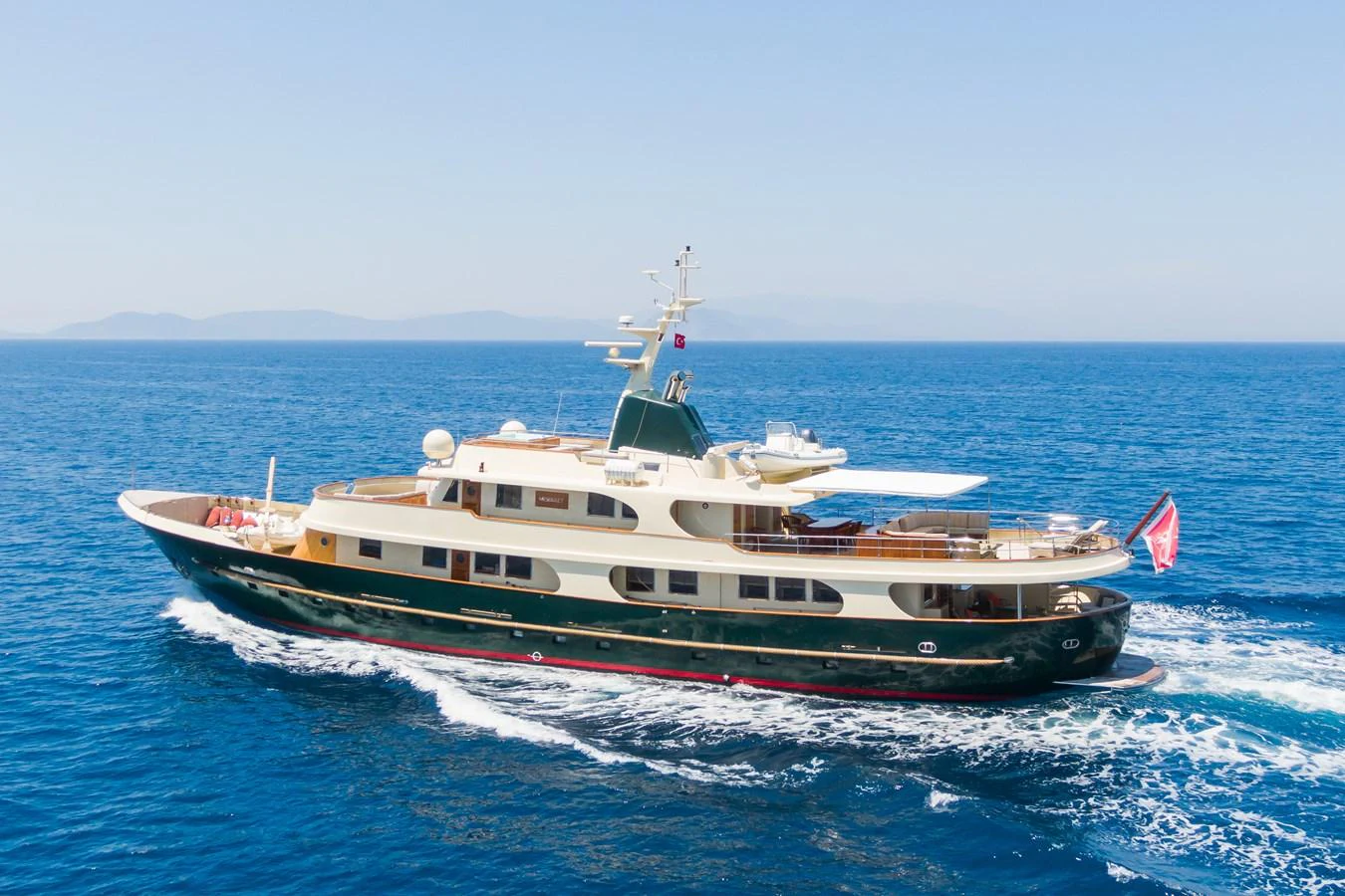 A luxurious yacht glides across the serene blue waters, showcasing its elegant design and spacious decks. aboard MESERRET Yacht for Sale