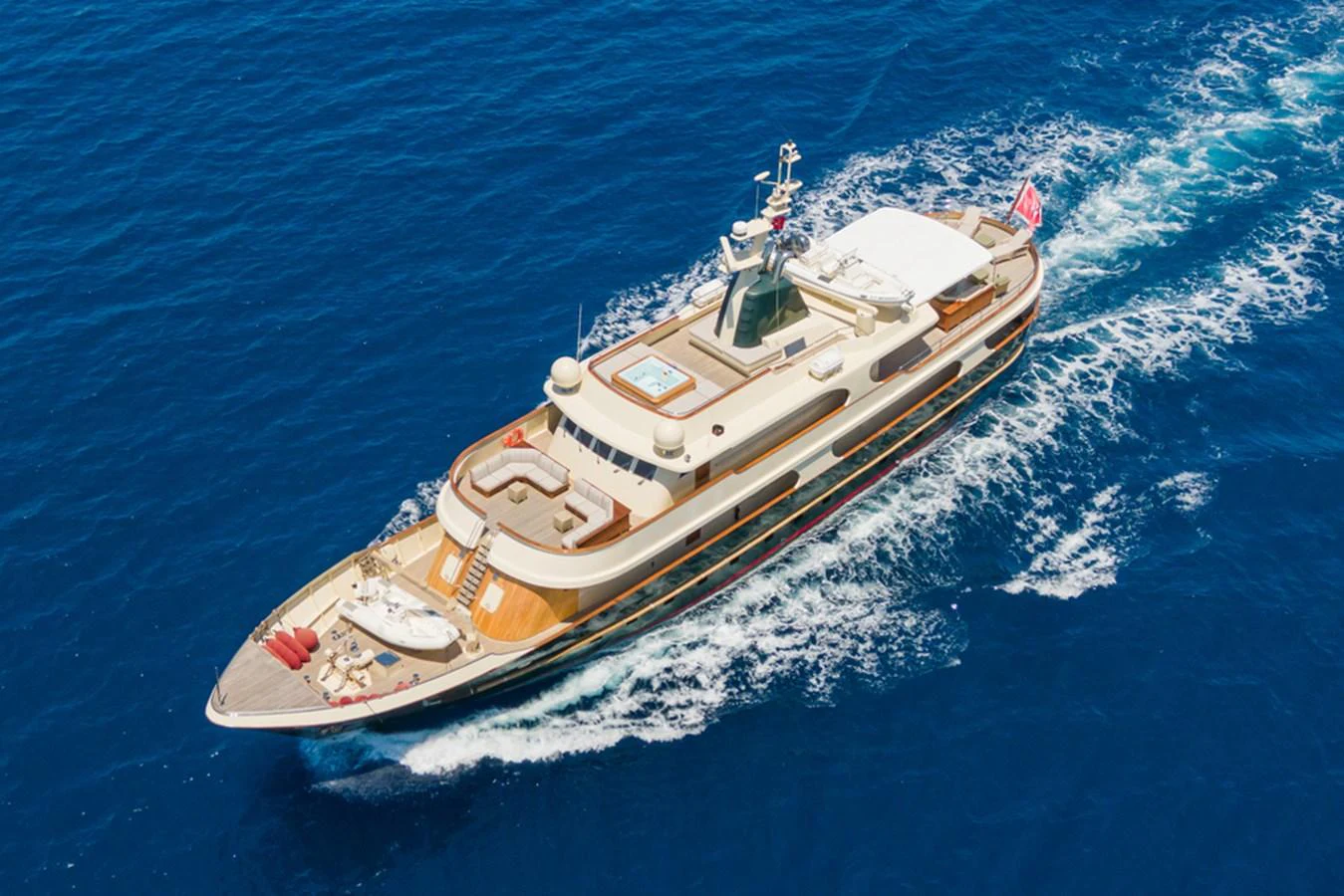 A luxurious yacht cruises through the vibrant blue waters, showcasing its elegant design and spacious deck areas. aboard MESERRET Yacht for Sale