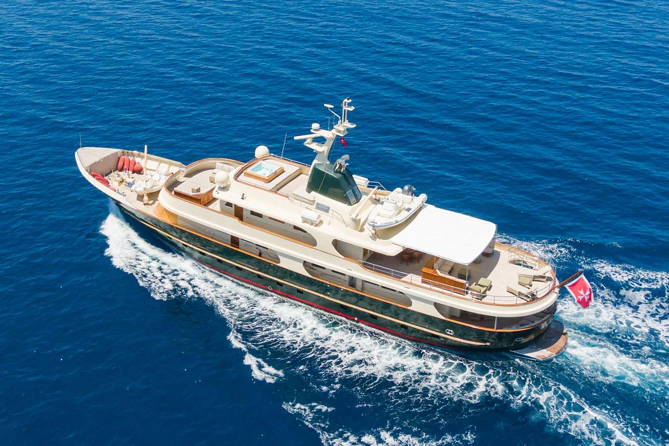 A luxurious yacht cruising through clear blue waters, showcasing its elegant design and spacious decks. aboard MESERRET Yacht for Sale