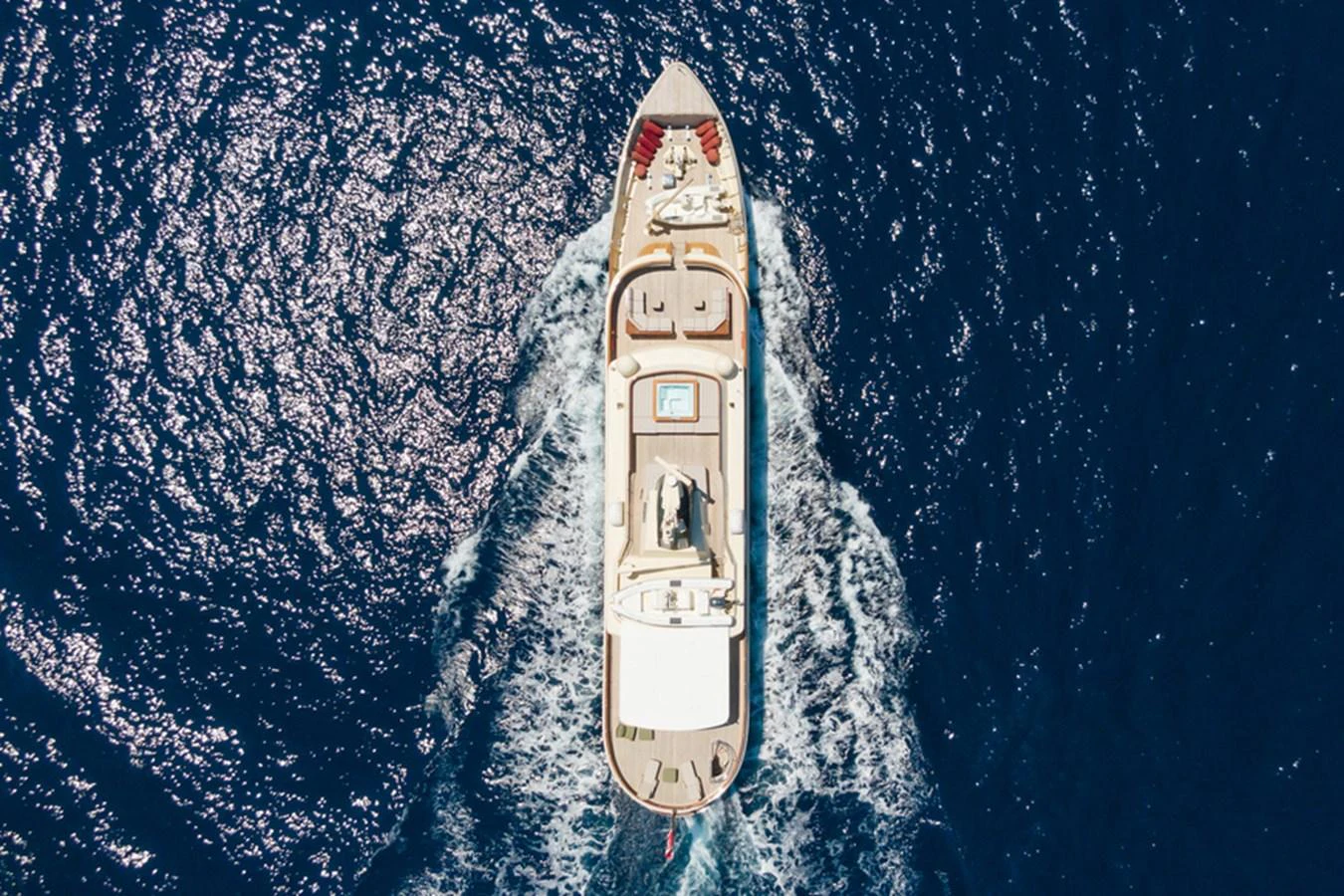 A luxurious yacht cruises through the deep blue sea, showcasing its elegant design from an aerial perspective. aboard MESERRET Yacht for Sale