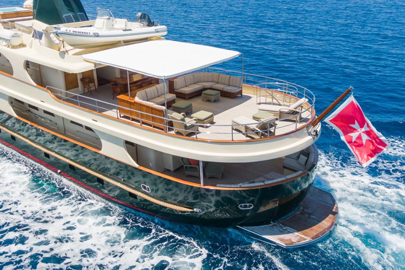 The yacht's aft deck features a spacious lounging area with comfortable seating and a large sunshade, perfect for relaxation while cruising. aboard MESERRET Yacht for Sale