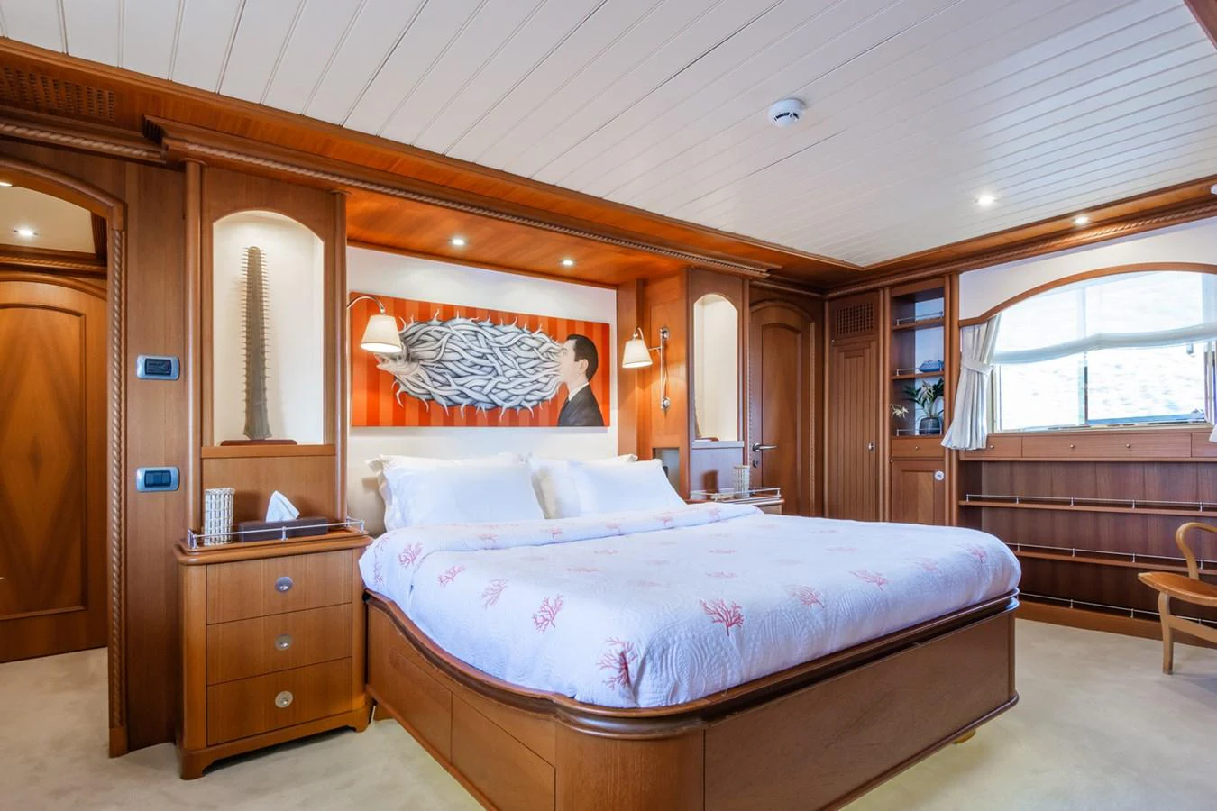 The master stateroom features a luxurious bed with elegant wood paneling and ample natural light. aboard MESERRET Yacht for Sale
