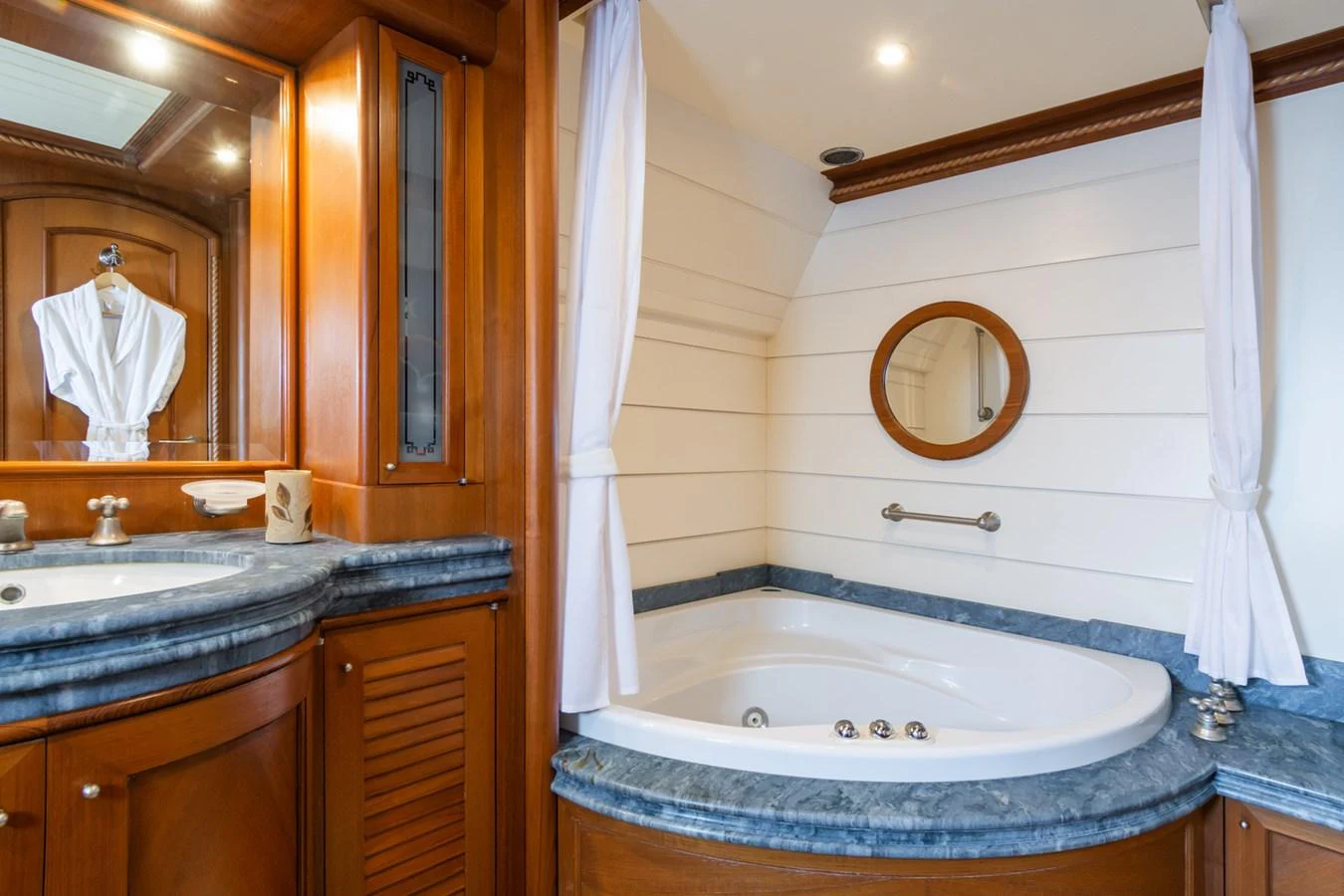 The yacht's bathroom features a luxurious jacuzzi tub and elegant wooden cabinetry. aboard MESERRET Yacht for Sale