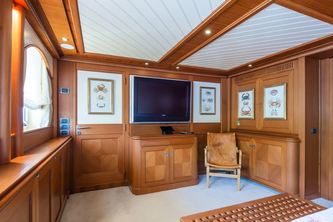 The yacht's salon features elegant wood paneling, a large flat-screen TV, and comfortable seating. aboard MESERRET Yacht for Sale