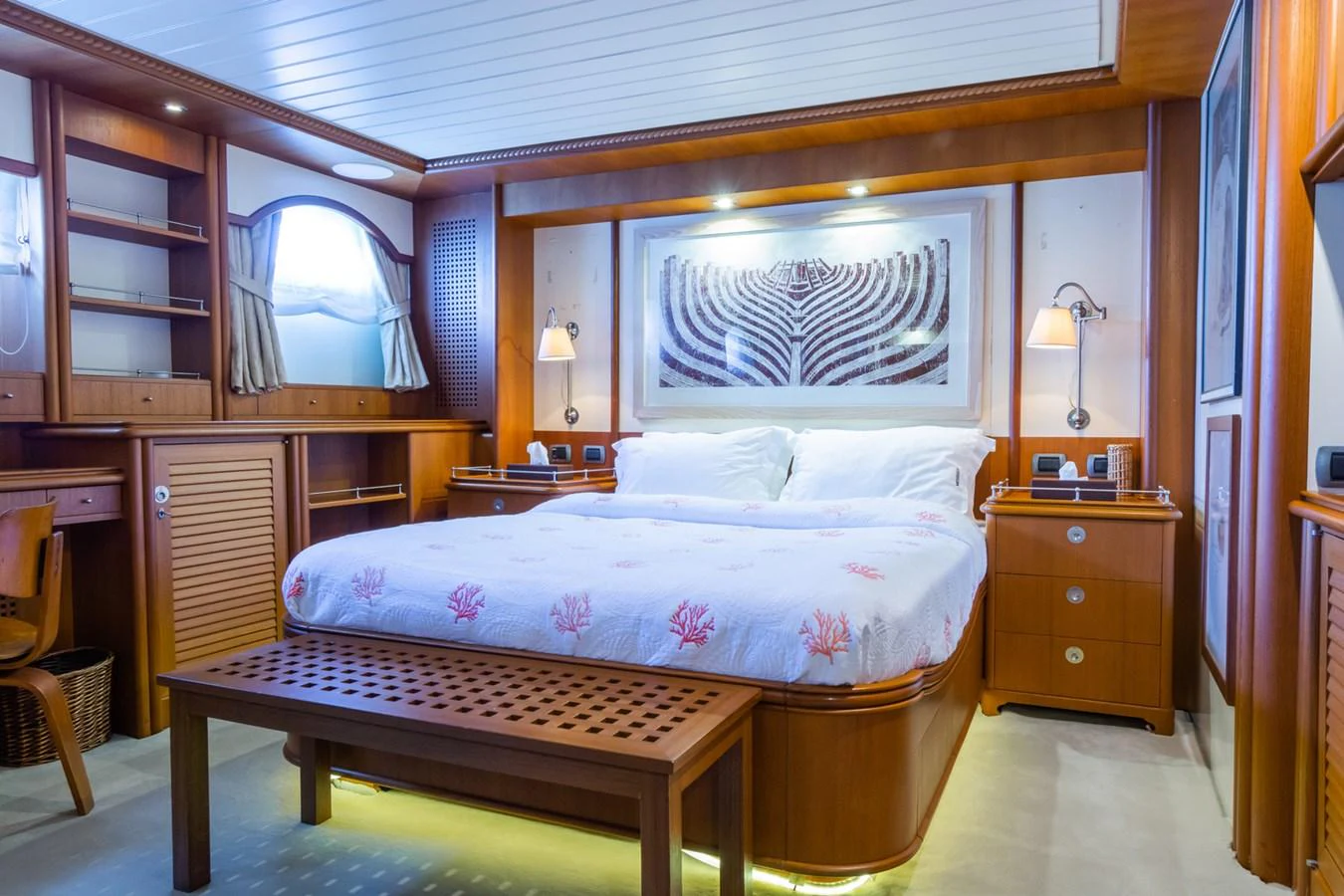 The master stateroom features a luxurious bed with elegant wooden furnishings and ambient lighting. aboard MESERRET Yacht for Sale