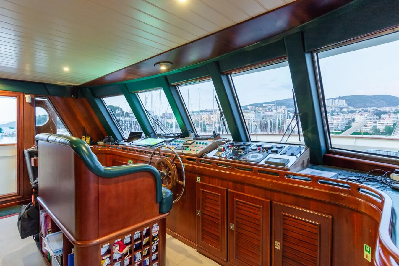 The helm station offers a commanding view with a blend of classic wood finishes and modern navigation equipment. aboard MESERRET Yacht for Sale