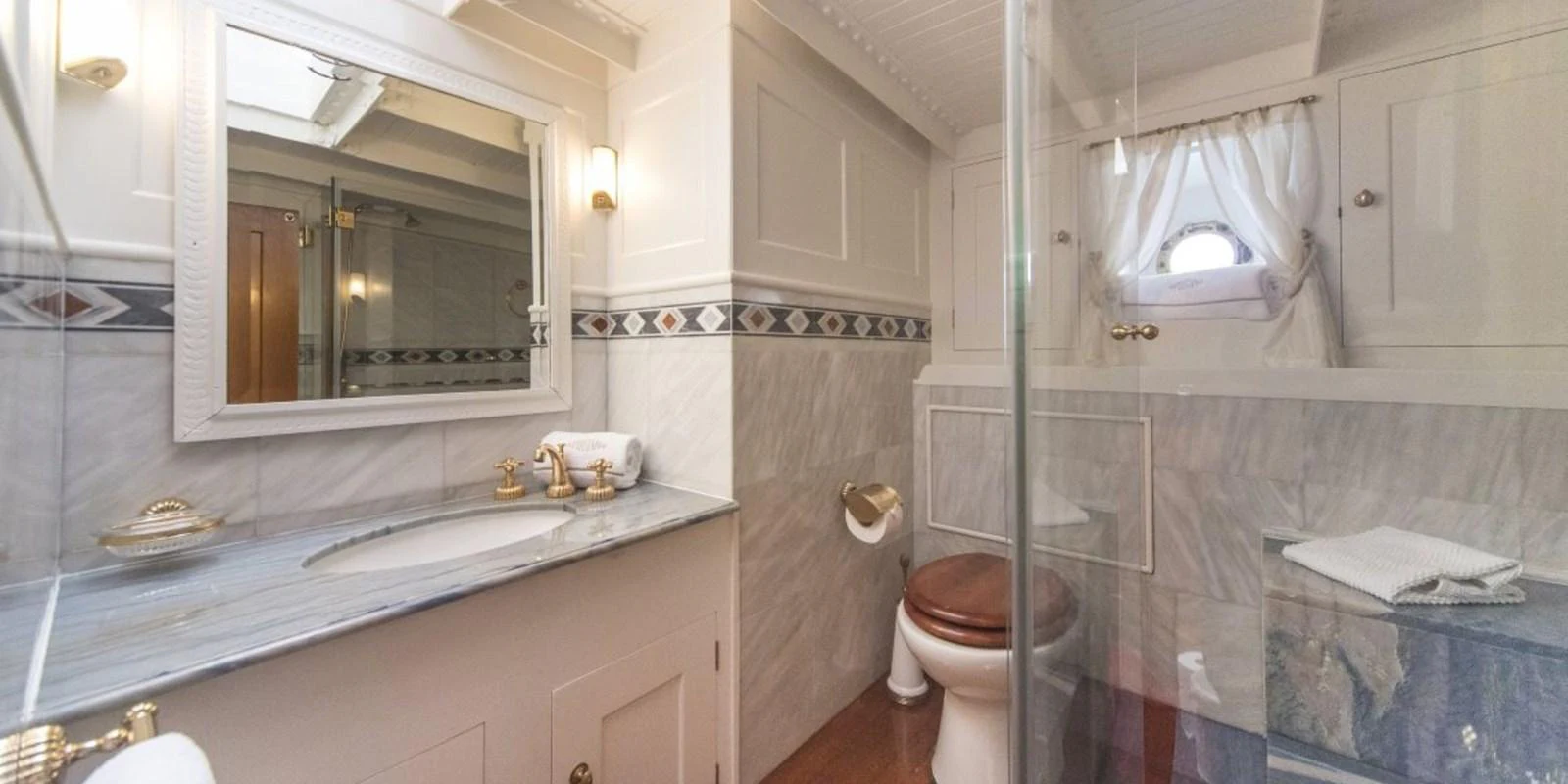 The yacht's bathroom features elegant fixtures and a classic design. aboard PURITAN Yacht for Sale