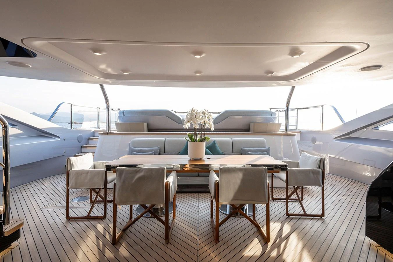 The aft deck features a stylish dining area with comfortable seating and a beautiful centerpiece. aboard TAMANYA Yacht for Sale