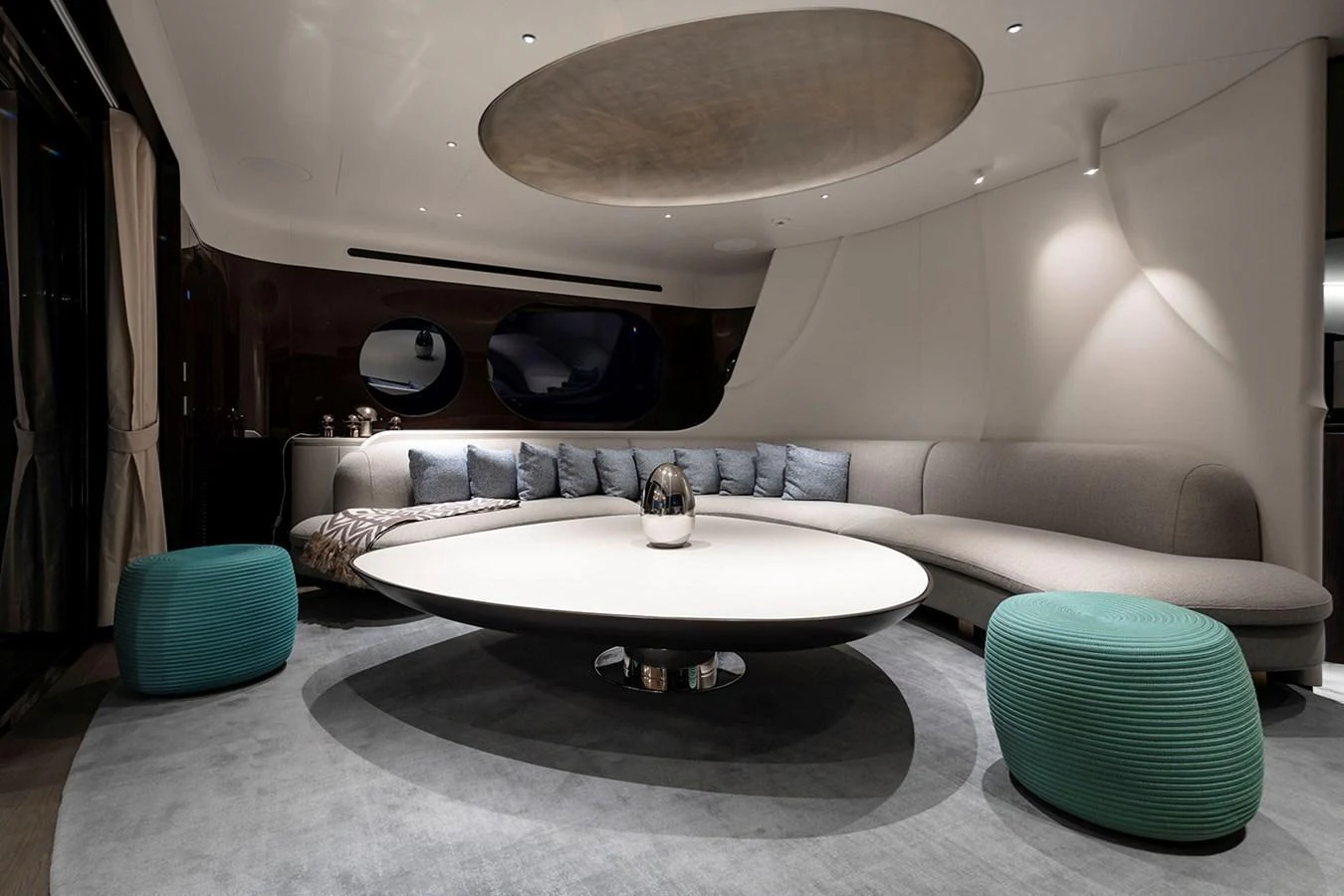 The salon features a modern, elegant design with a large circular table and comfortable seating. aboard TAMANYA Yacht for Sale