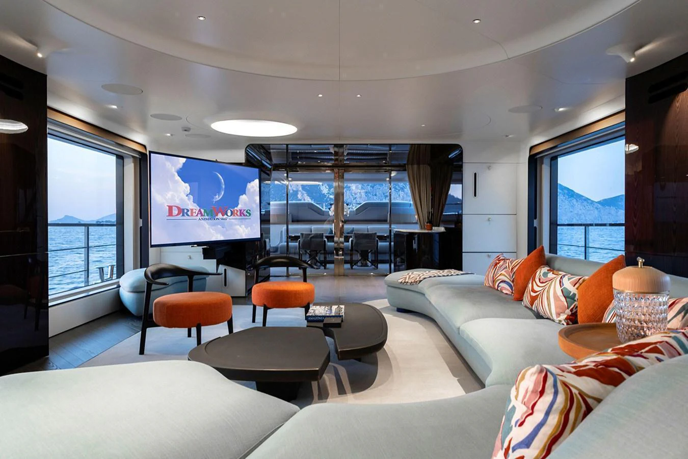 The luxurious salon features modern furnishings, large windows, and a spacious seating area with a stunning sea view. aboard TAMANYA Yacht for Sale