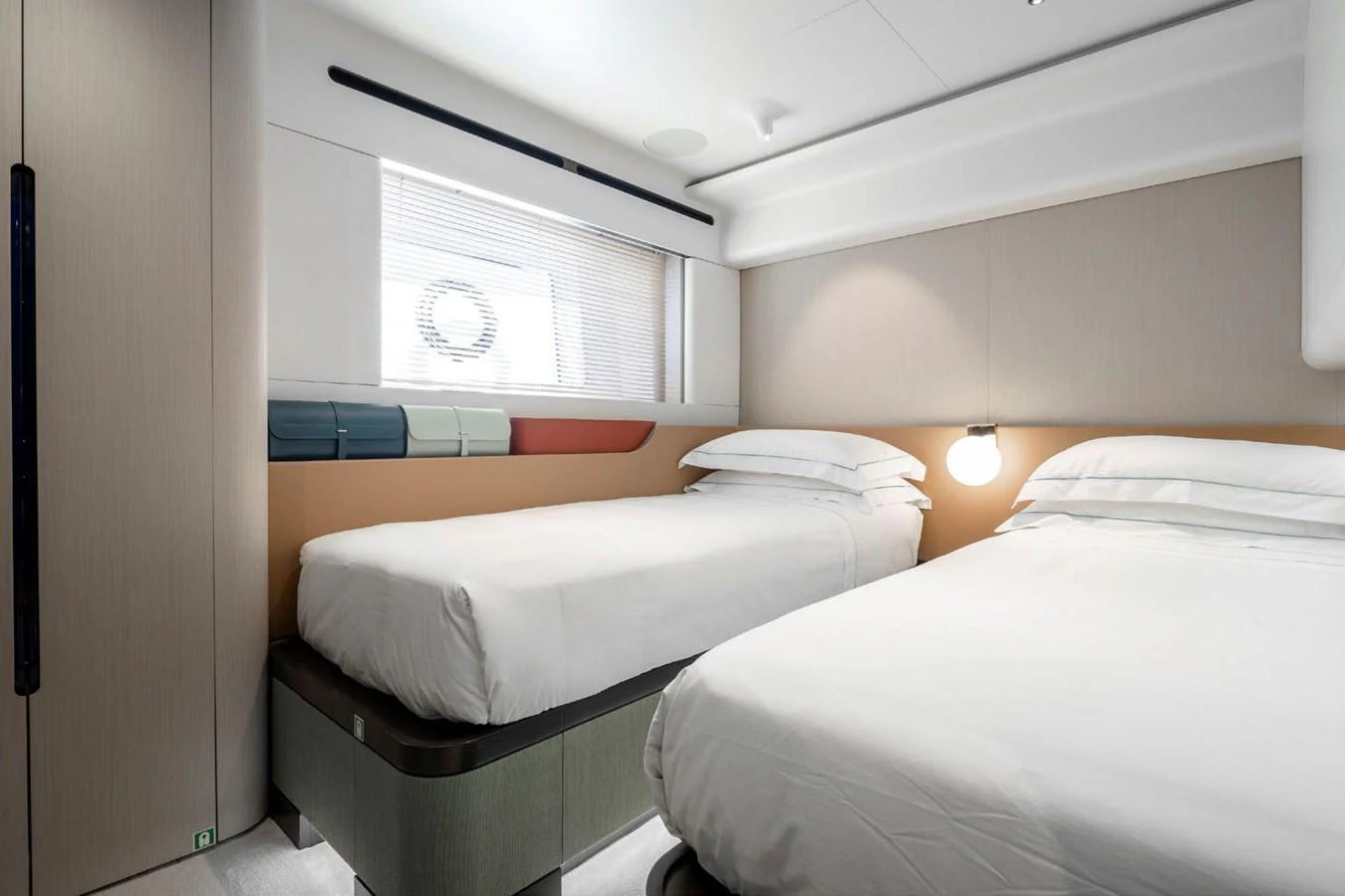 The guest cabin features two single beds with modern, minimalist decor and ample natural light. aboard TAMANYA Yacht for Sale