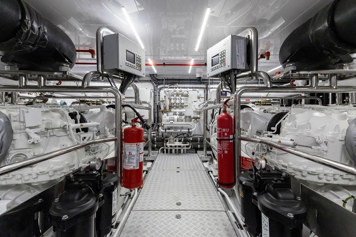 The image showcases a pristine and well-organized engine room with advanced machinery and safety equipment. aboard TAMANYA Yacht for Sale