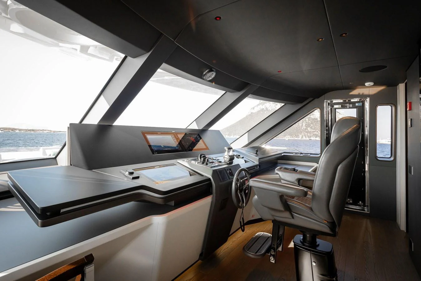 The helm station features modern navigation equipment and a comfortable captain's chair with panoramic views. aboard TAMANYA Yacht for Sale