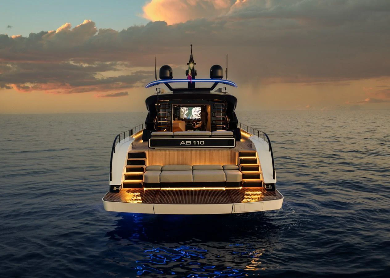The yacht's aft deck is beautifully illuminated against a serene sunset backdrop. aboard AB 110 Yacht for Sale