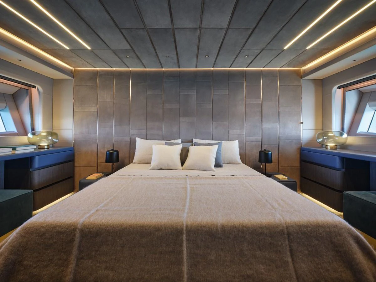 The master stateroom features a luxurious bed with modern lighting and elegant decor. aboard AB 110 Yacht for Sale