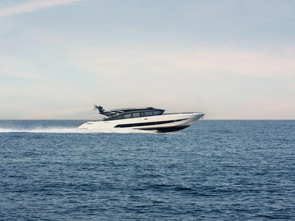 A sleek, modern yacht cruises swiftly across the open sea. aboard AB 110 Yacht for Sale