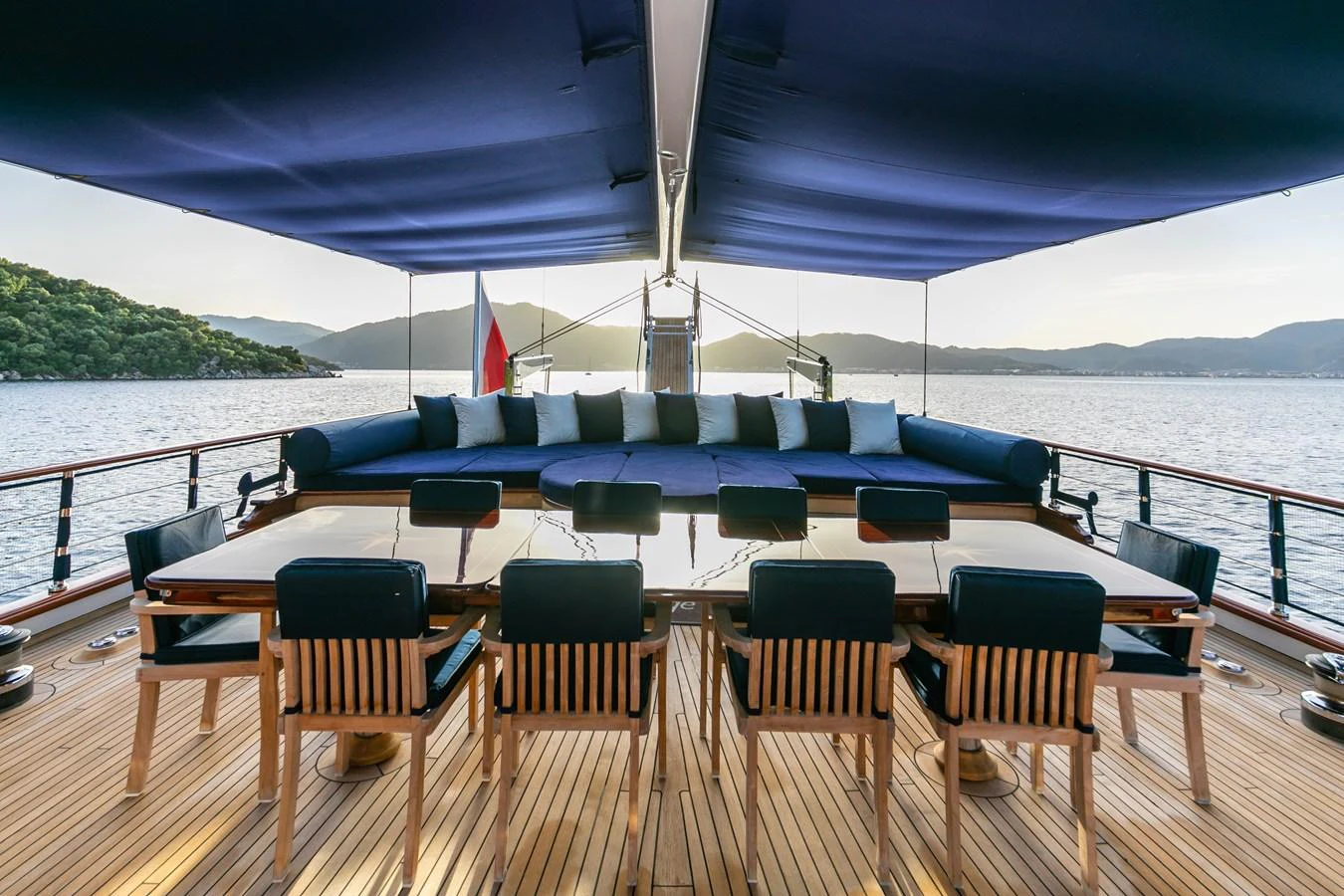 The aft deck features a spacious dining area with comfortable seating and a stunning view of the surrounding waters. aboard VOYAGE Yacht for Sale