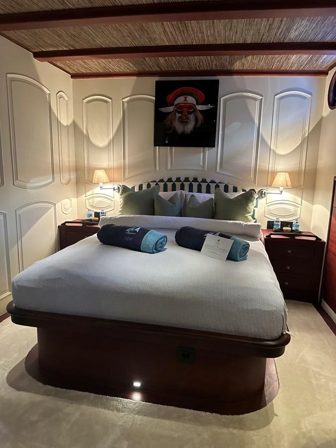 The stateroom features a cozy bed with elegant lighting and tasteful decor. aboard VOYAGE Yacht for Sale