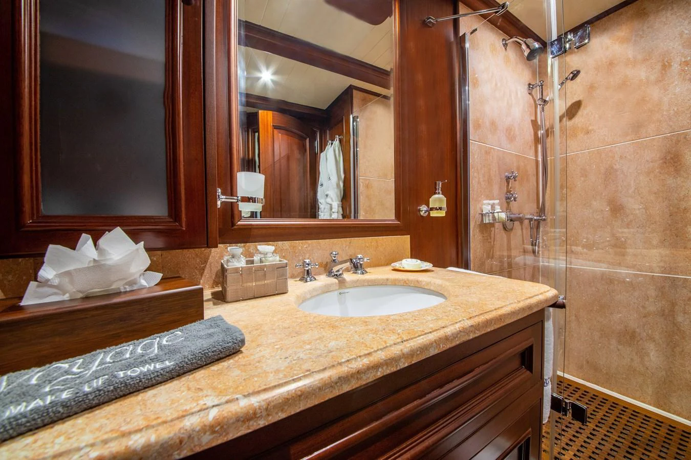The yacht's bathroom features a luxurious design with rich wood accents and modern fixtures. aboard VOYAGE Yacht for Sale
