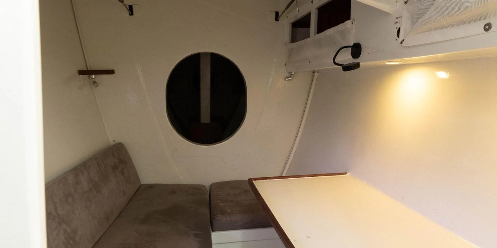 A cozy interior space with a small table and seating area, illuminated by soft lighting. aboard MAXICAT VICTORIA Yacht for Sale