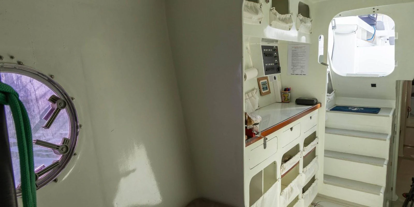 A functional interior space featuring a compact work area and steps leading to another level. aboard MAXICAT VICTORIA Yacht for Sale