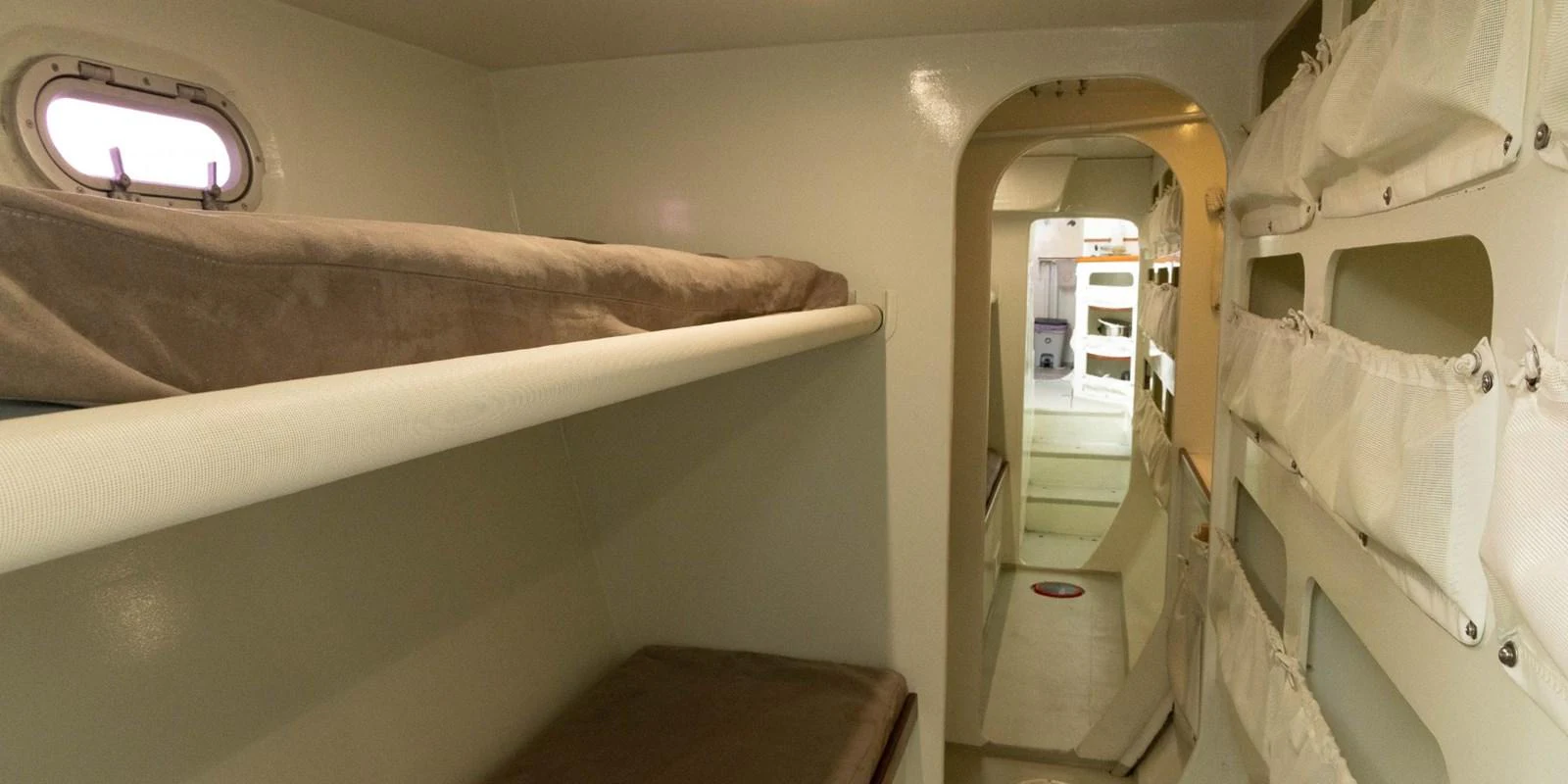 The image shows a functional crew quarters with bunk beds and storage compartments. aboard MAXICAT VICTORIA Yacht for Sale