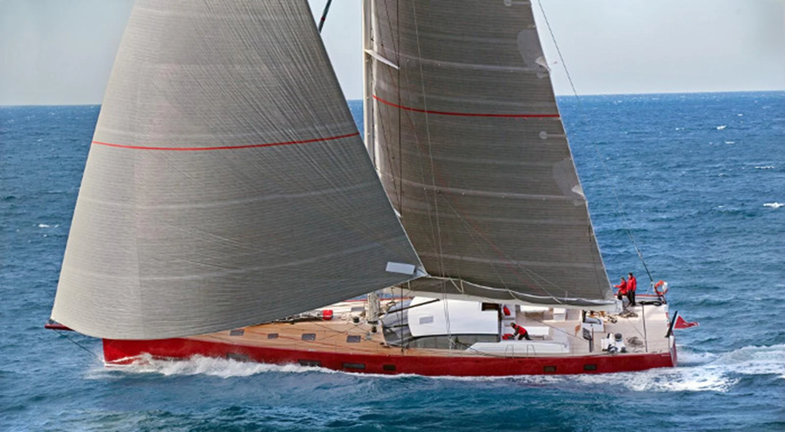 A sleek sailing yacht glides effortlessly through the open sea, showcasing its impressive sails and modern design. aboard NOMAD IV Yacht for Sale