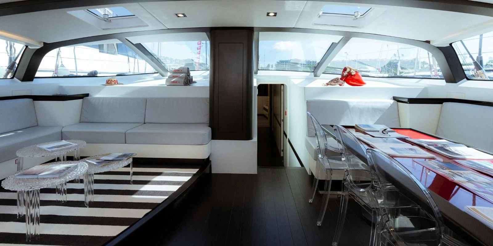 The salon features modern furnishings with ample natural light streaming through large windows. aboard NOMAD IV Yacht for Sale