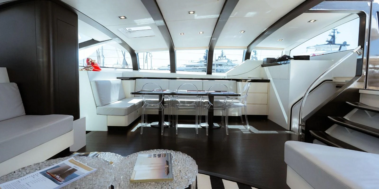 The salon features modern furnishings with ample natural light from large windows. aboard NOMAD IV Yacht for Sale