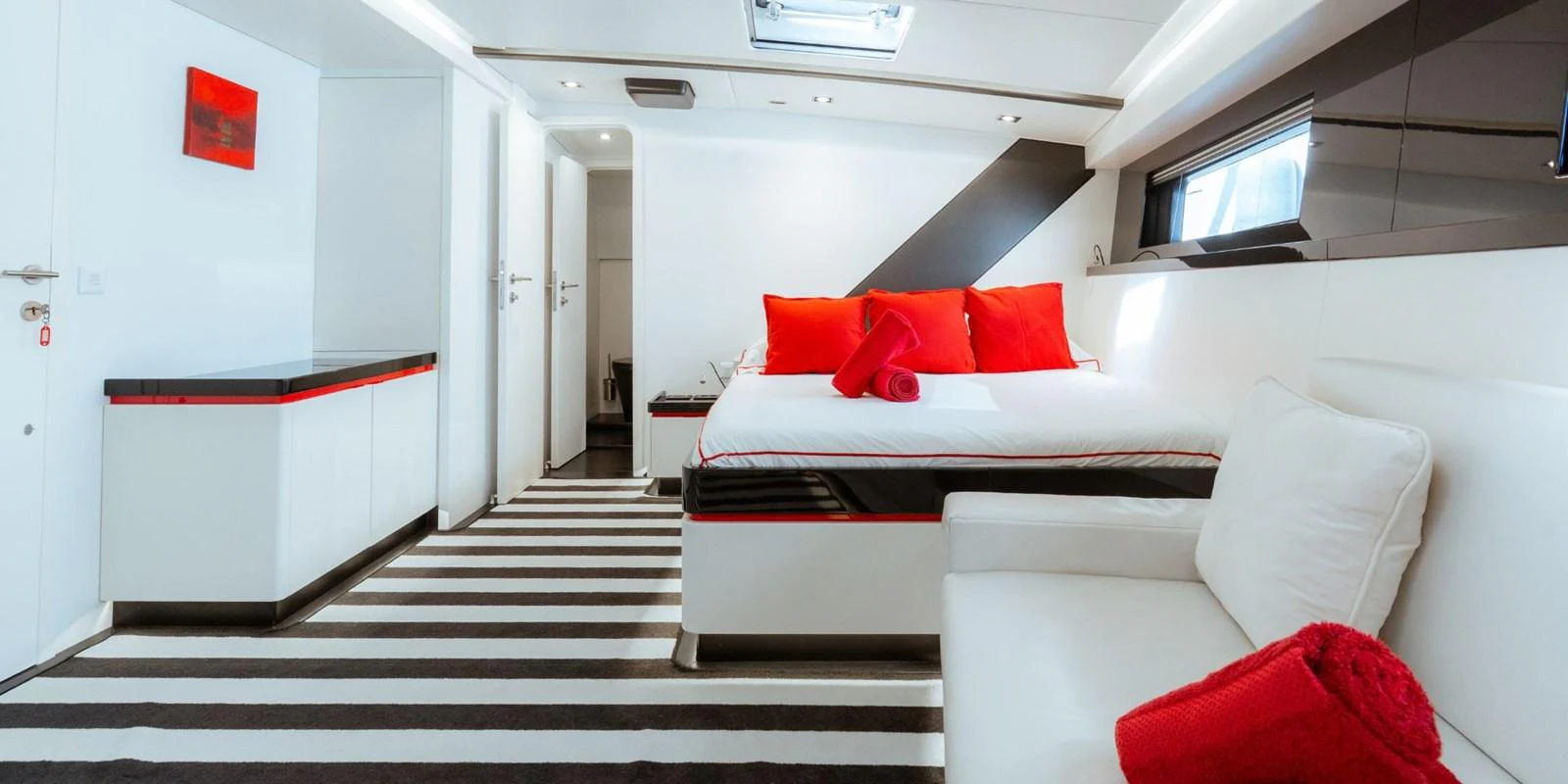 The stateroom features a modern design with a comfortable bed, stylish decor, and ample natural light. aboard NOMAD IV Yacht for Sale