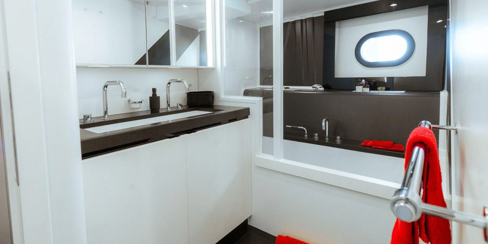 A modern yacht bathroom featuring a sleek design with dual sinks and a bathtub. aboard NOMAD IV Yacht for Sale