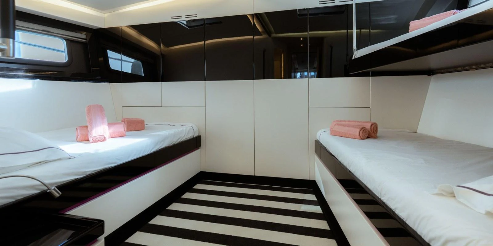 The guest stateroom features twin beds with a modern, sleek design and ample storage. aboard NOMAD IV Yacht for Sale