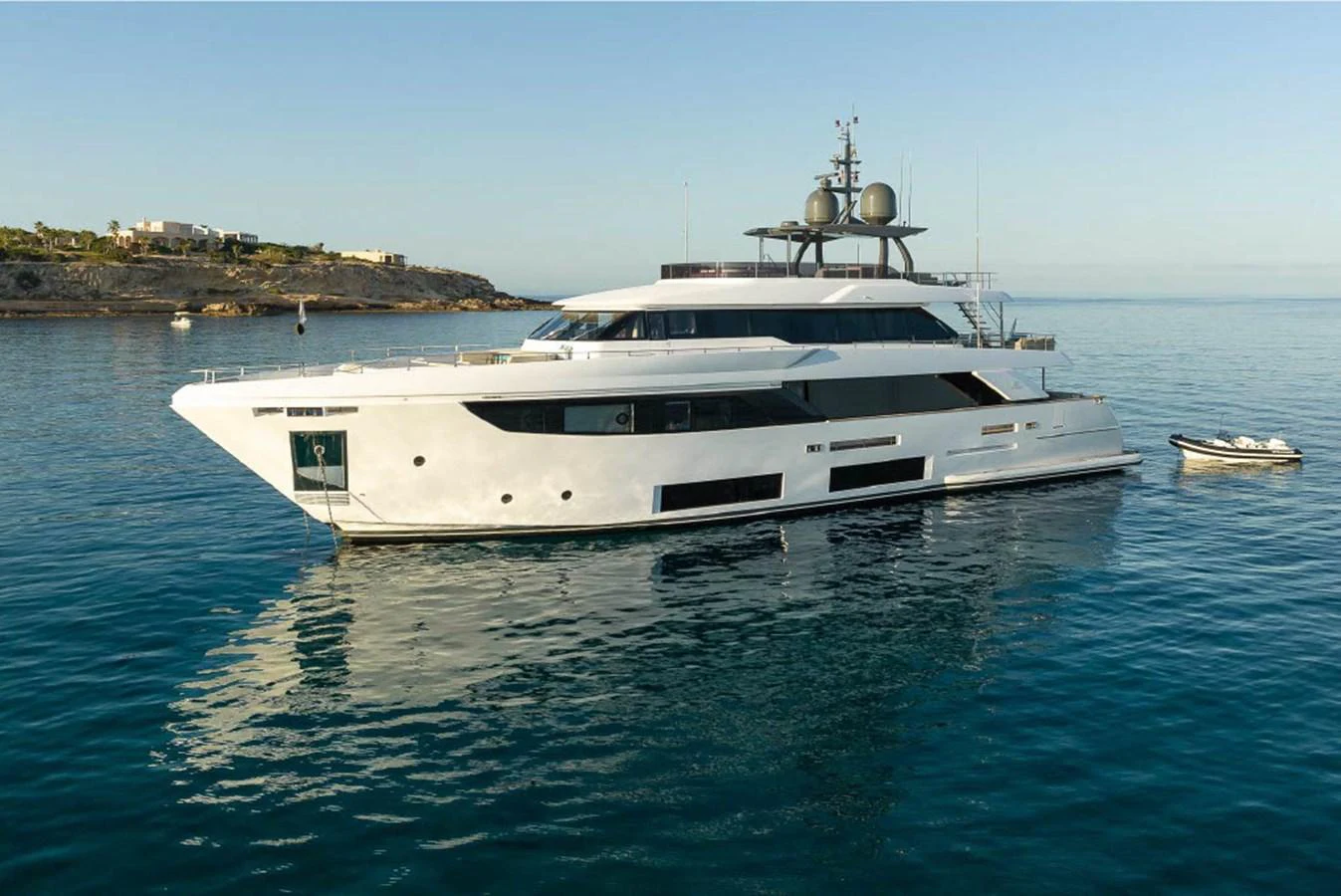 A sleek and modern yacht is anchored in calm waters, showcasing its elegant design and spacious decks. aboard ON Yacht for Sale
