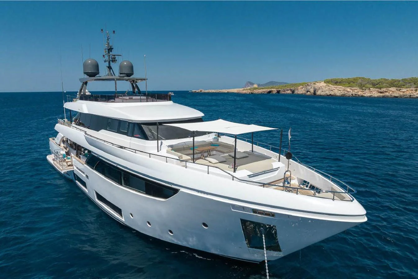 A sleek and modern yacht cruising on calm blue waters with a scenic coastline in the background. aboard ON Yacht for Sale