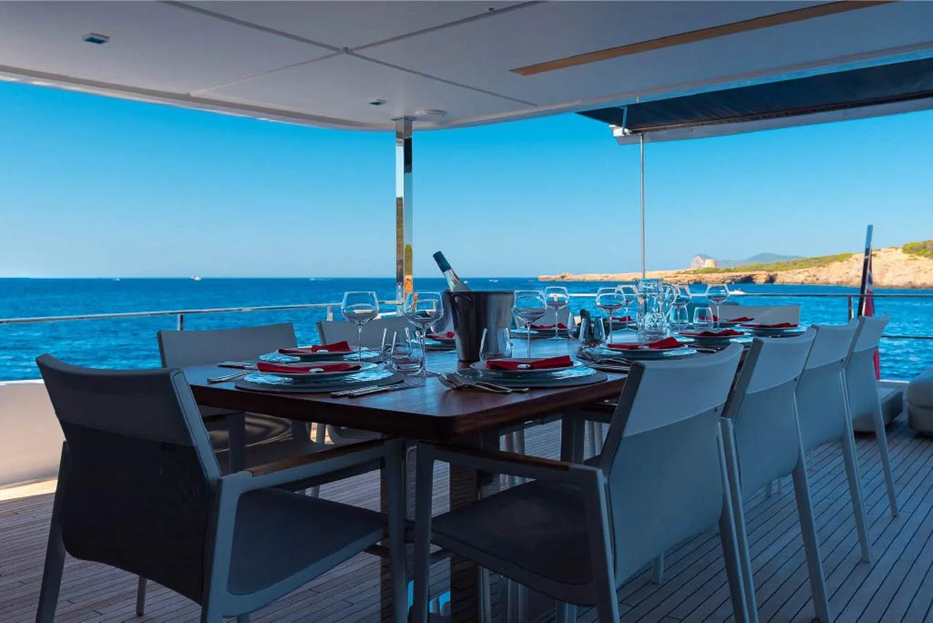 The aft deck features an elegant dining area with a stunning ocean view. aboard ON Yacht for Sale