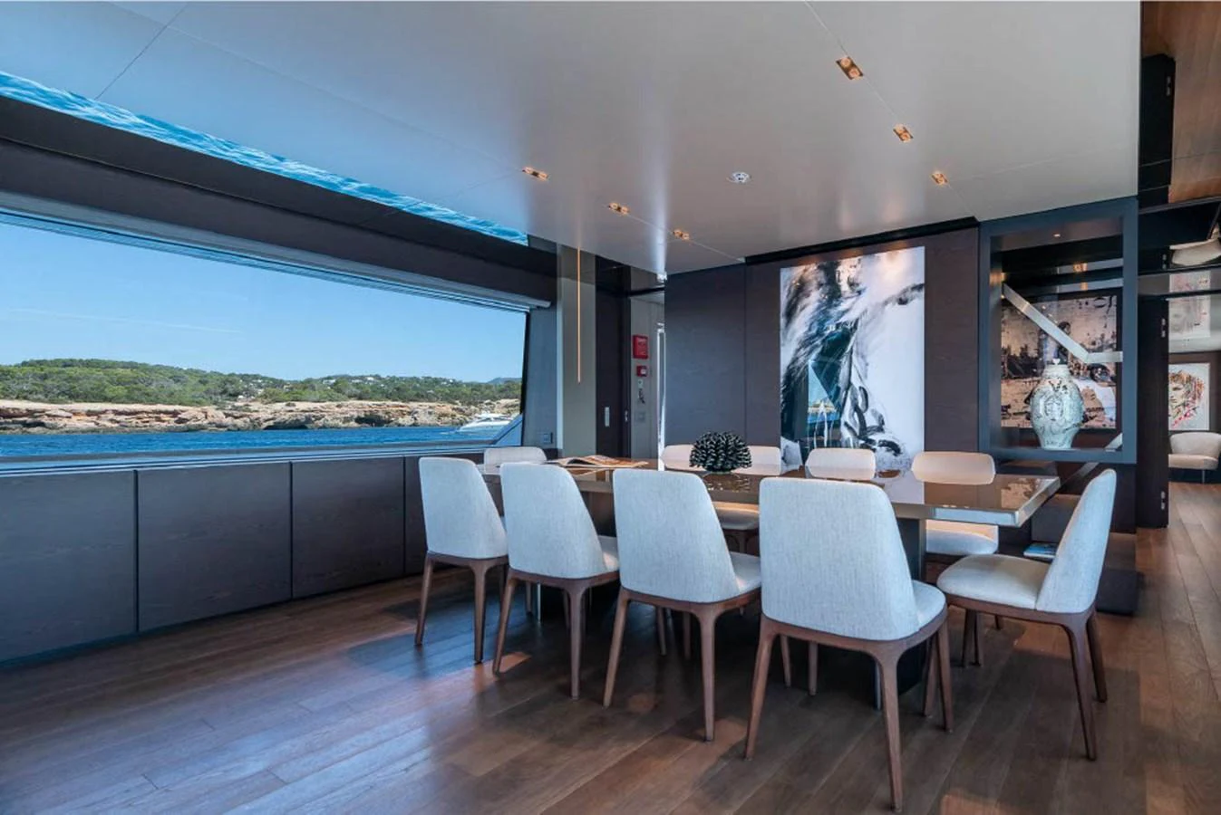 The yacht's dining area features a large table with elegant seating and expansive windows offering stunning views. aboard ON Yacht for Sale