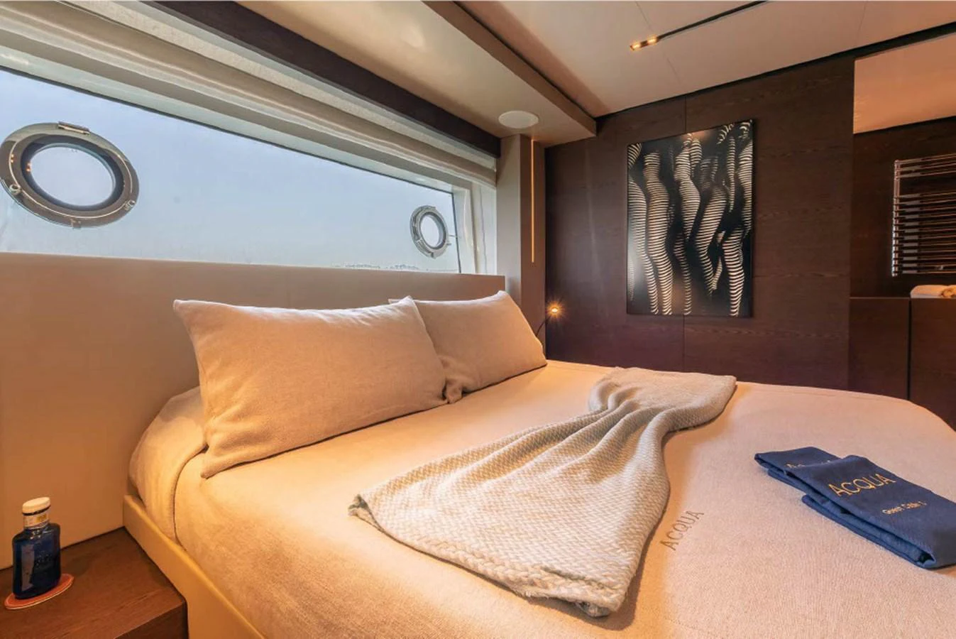 The stateroom features a plush bed with elegant linens and a large window offering a serene view. aboard ON Yacht for Sale