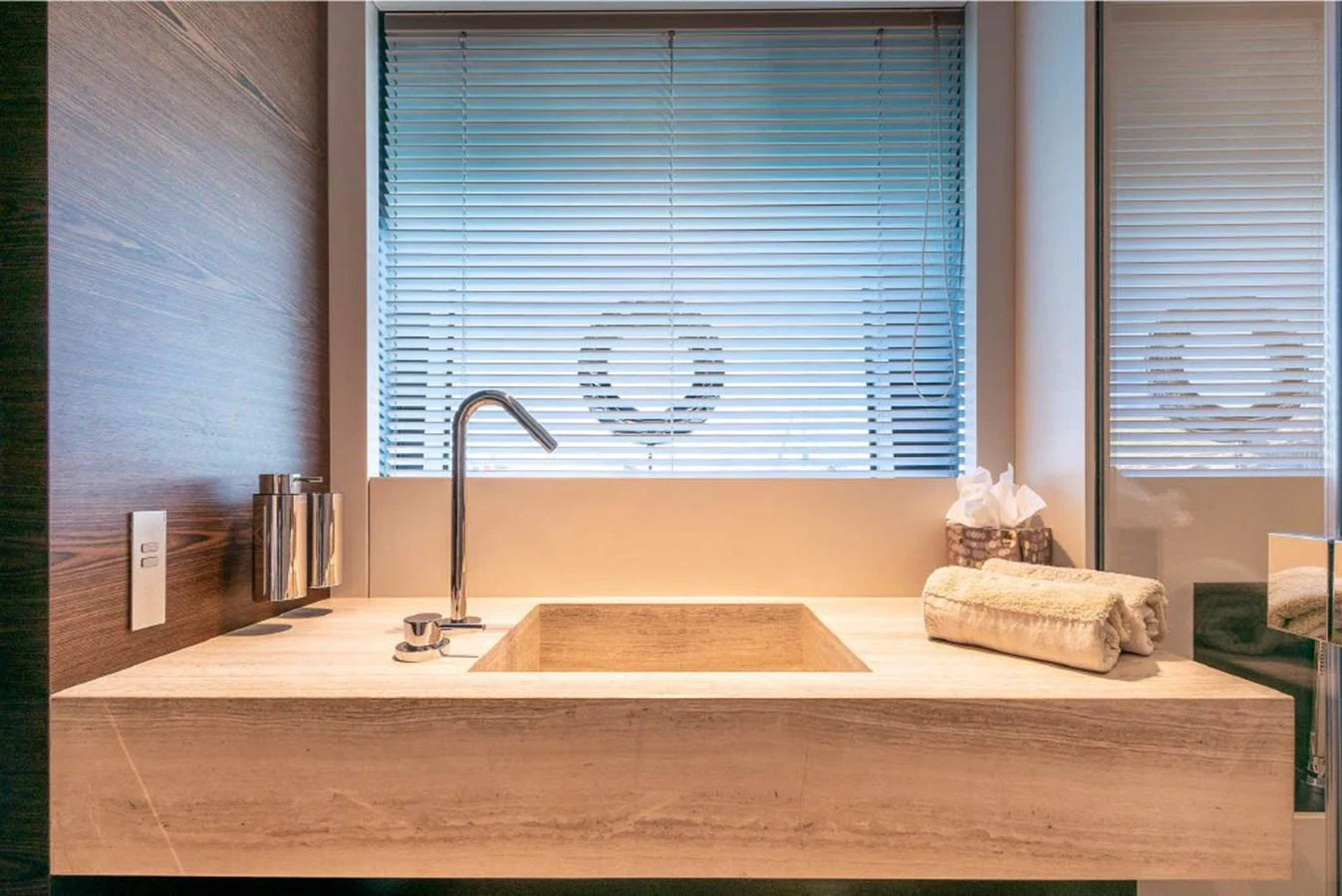 The yacht's bathroom features a sleek, modern sink with a stylish faucet and a large mirror. aboard ON Yacht for Sale